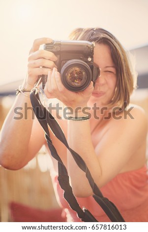 Cute young indie photographer girl taking a picture with her dslr camera