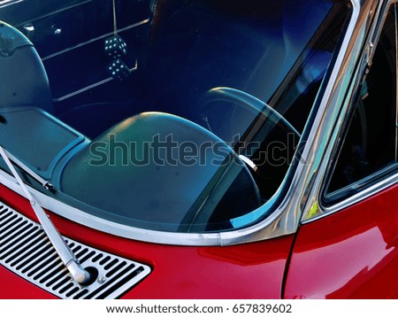 steering wheel of a classic red sedan