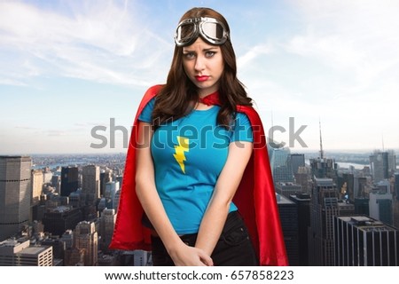 Sad pretty superhero girl with the city in the background