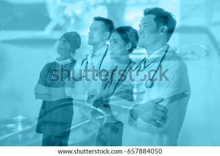 Team of doctors and nurses looking up at hospital