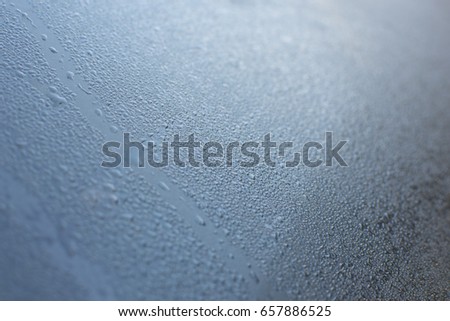 Window glass with condensation and high humidity on the car glass. cold tone.