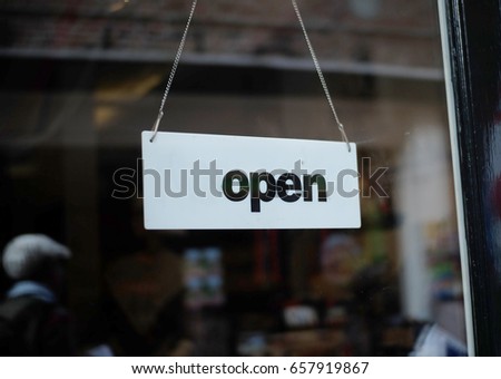 An 'Open' sign is hanging at front of store entrance. Business concept. Marketing concept. Business hours. Store has an open sign for welcoming customer to shop inside.