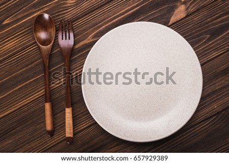 Empty white plate with spoon and fork. view from top