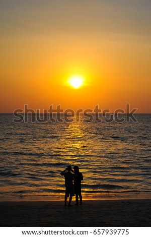 Beautiful Sunset at andaman sea with silhouette people together, Phuket Thailand