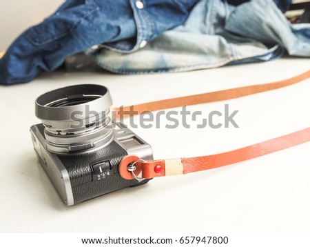 Genuine leather camera strap with mirorless camera on white background