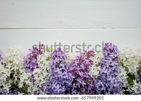 Background, frame with branches of lilac in different colors - white, lilac and purple on a white-painted wooden boards. Top view. Copy space. The theme of spring, summer, good morning 