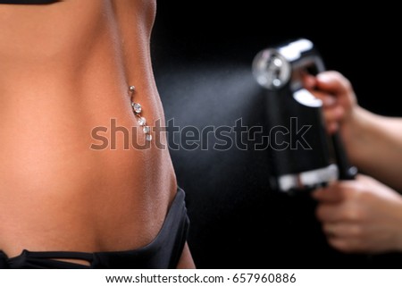 Woman body paint with airbrush in professional beauty salon Royalty-Free Stock Photo #657960886