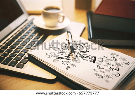 Close up and side view of office desk with laptop, coffee cup and drawing in notepad. Idea concept