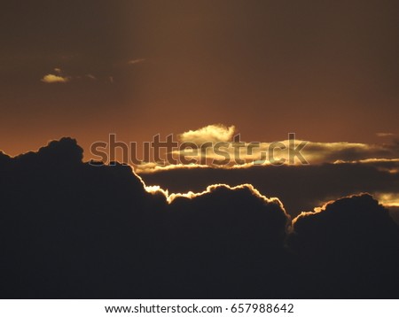 Evening Sunset Black clouds with golden light rays. Clouds with gold color edges