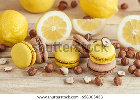 Yellow and brown french macarons with lemon and hazelnuts, soft focus background