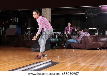 Young woman having fun and playing bowling