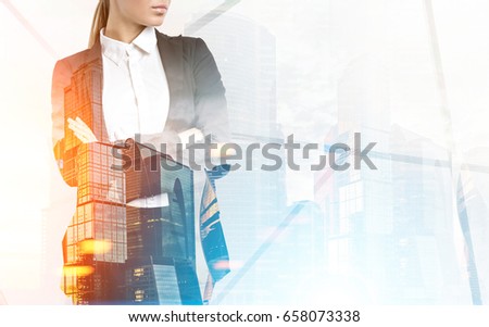 Close up of a businesswoman with long blond hair standing with crossed arms against a morning city panorama. Toned image, mock up, double exposure