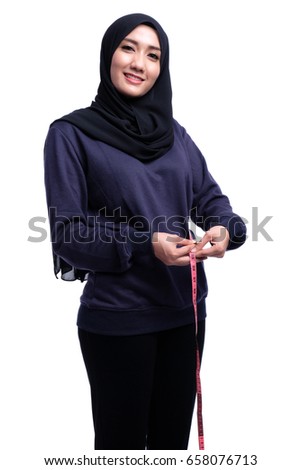 Muslim woman fitness taking measurements of her body or Weight loss, slim body, healthy lifestyle concept. Fit fitness girl measuring her waistline body with many colorful measure tapes