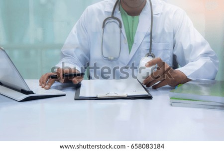 Doctor writing a medical prescription at desk in the hospital. 