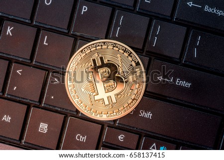 gold bitcoin coin on the keyboard. close up