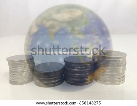 The concept of worldwide investment. Closeup coin stacks with blurry simulation globe background. Blurry with selective focus.