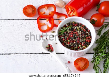White wooden background with spices, pepper and rosemary. Ingredients for cooking. Top view.