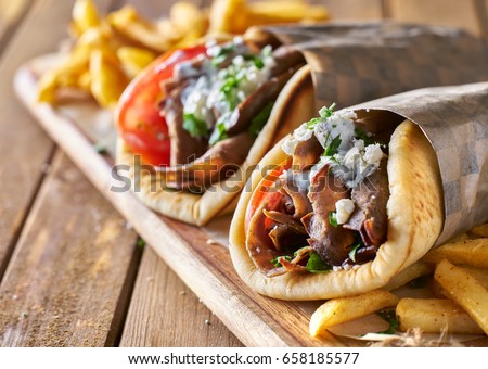 two greek gyros with shaved lamb and french fries Royalty-Free Stock Photo #658185577