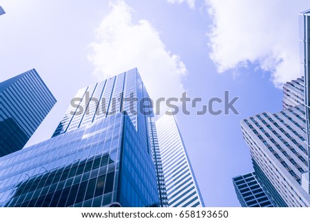 Upward view of skyscrapers against a cloud blue sky in the business district area of downtown Houston, Texas, US. Vintage tone
