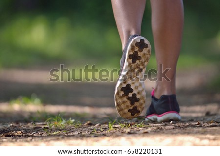 Runner legs on the pathway in the park. Healthy lifestyle concept. Close up picture of feet of young woman