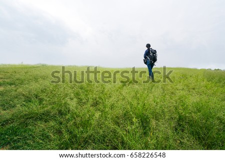 The women walking on the grass of the mountain. The idea  concept of journey, destination and the goal of life.