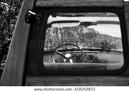 a view on an old car interior, trough window. a car maded with wood, with a vintage style. (black and white version)