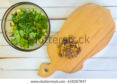 Preparation of a vegetarian salad. Cutting walnuts