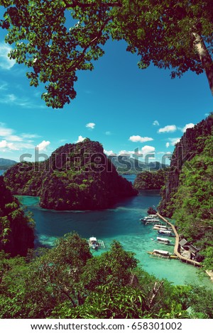 Elevated view of lagoon with boats surrounded by rocks and turquoise sea. Coron. Palawan.