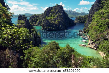 Elevated view of lagoon with boats surrounded by rocks and turquoise sea. Coron. Palawan