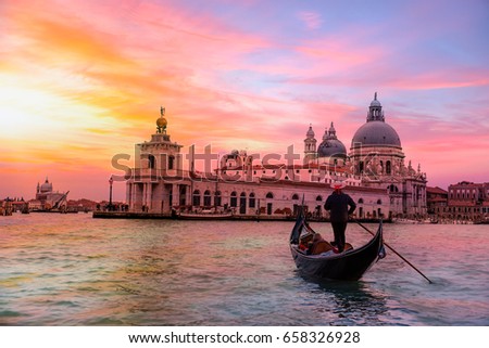 Venetian gondolier punting gondola through green canal waters of Venice Italy Royalty-Free Stock Photo #658326928