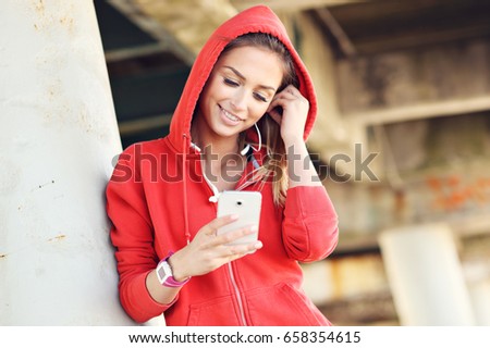 Woman jogging on the beach with smartphone