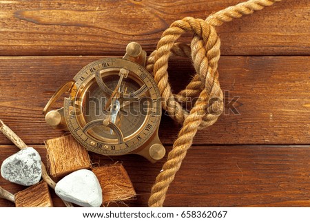 Compass and rope on wooden table. close up