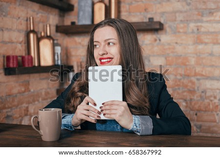 Young freelancer girl is working hard in laptop in loft interior