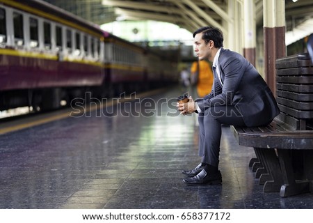 business man waiting on the chair at train station .  Sad,work,depressed,alone,upset concept
