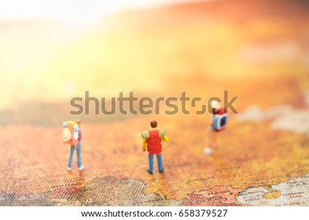 Miniature backpacker on vintage map using as background travel or business concept.