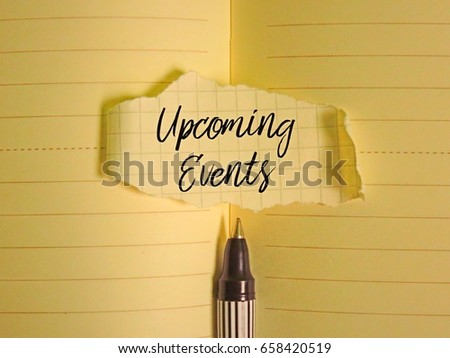 A pen and piece of paper written ' Upcoming Events ' on paper background.