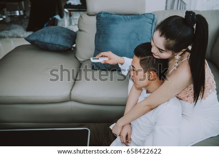 Asian couple watch television in the livingroom