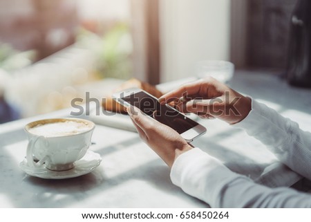 Girl pointing finger on screen smart phone during coffee break,  Female hands using modern device while resting at coffee shop