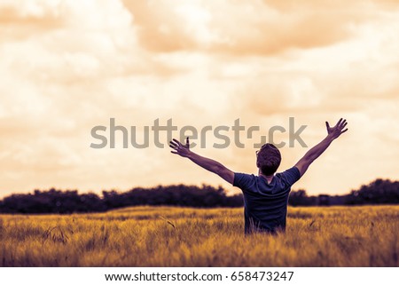 young man raise his hands to the sky 