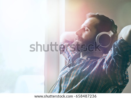 handsome bearded man  in headphones listening to music Royalty-Free Stock Photo #658487236