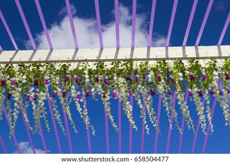 Decorative arch with flowers of wisteria on a background of blue sky