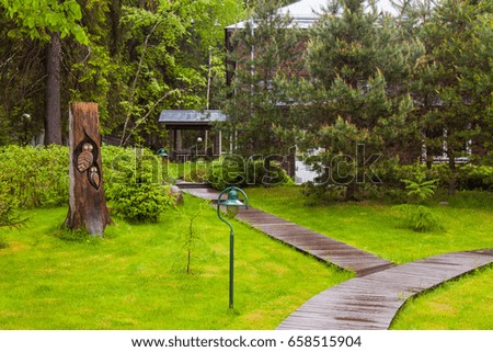 Wooden figure of an owl in a park with paths