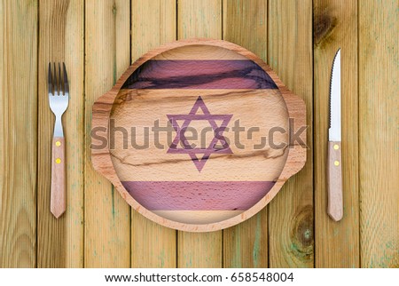 Concept of Israeli cuisine. Wooden plate with a Israel flag, fork and knife on a wooden background