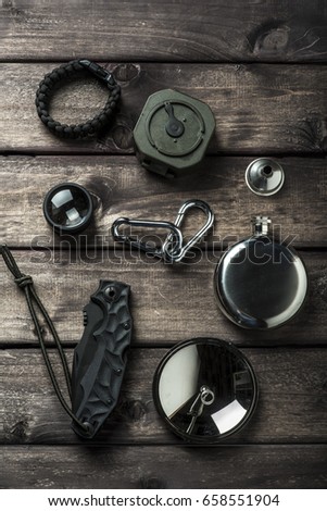 hiking travel gear on wood backdrop. Flat lay of outdoor travel equipment items for mountain camping trip.

