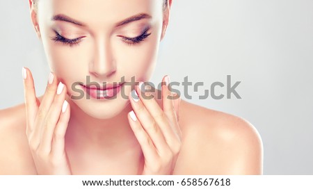 Beautiful Young Woman with Clean Fresh Skin close up . Skin care face . Cosmetology ,beauty  and spa . Girl washes and cleans her face Royalty-Free Stock Photo #658567618
