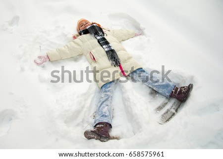 Young girl making a snow angel