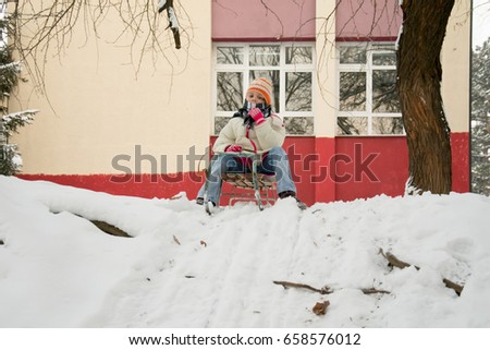 Girl On A Sled Playing In The Snow