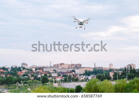 drone quad copter with high resolution digital camera flying hovering over the city