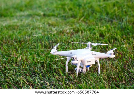 Drone with camera in the grass preparing to fly