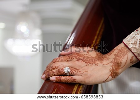 Brides henna covered hand on bannister